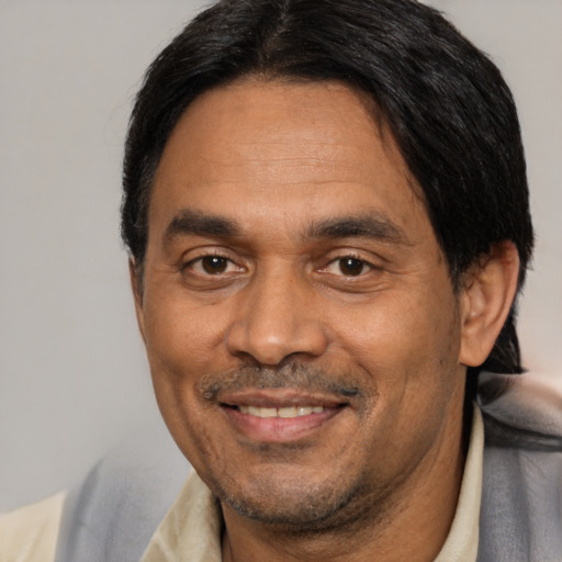 Joyful latino adult male with short  black hair and brown eyes