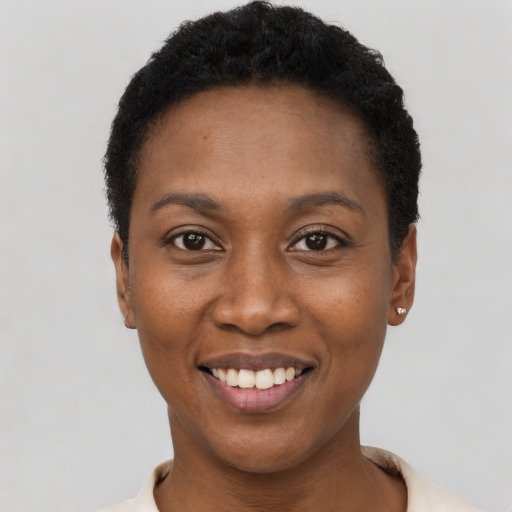 Joyful black young-adult female with short  black hair and brown eyes