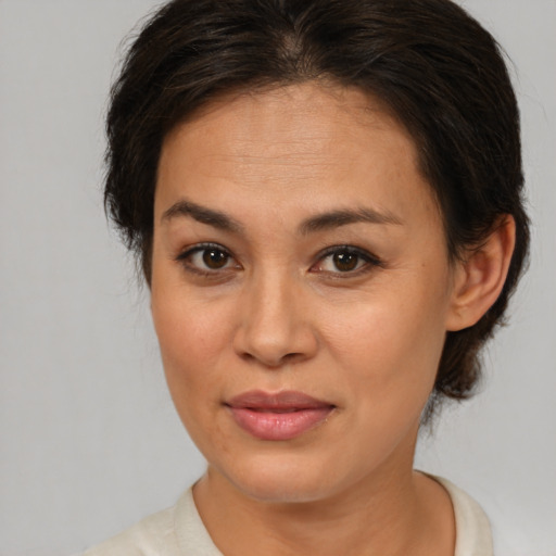 Joyful latino adult female with medium  brown hair and brown eyes