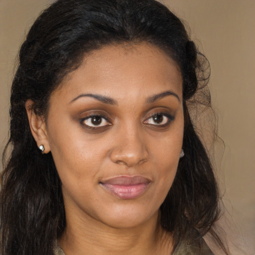 Joyful black young-adult female with long  brown hair and brown eyes