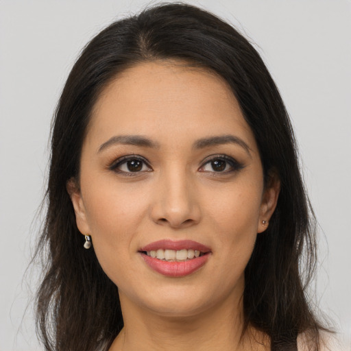 Joyful latino young-adult female with long  brown hair and brown eyes