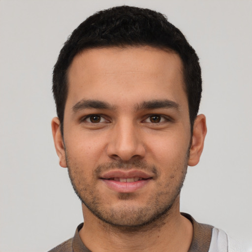Joyful latino young-adult male with short  black hair and brown eyes