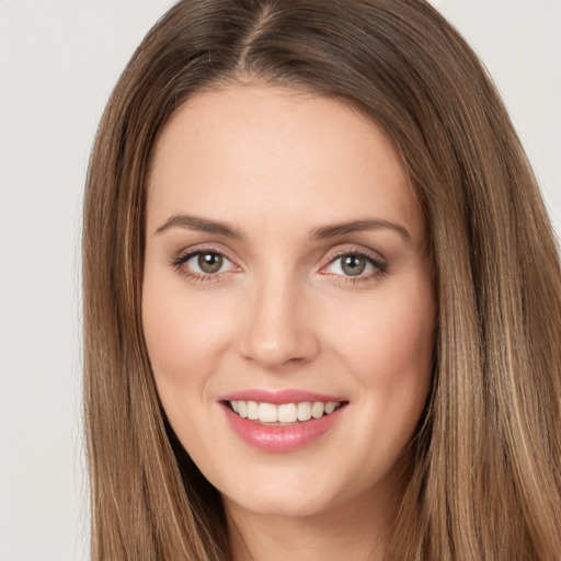 Joyful white young-adult female with long  brown hair and green eyes