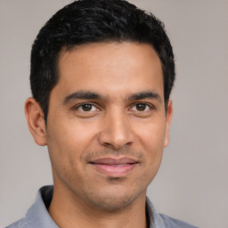 Joyful latino young-adult male with short  black hair and brown eyes