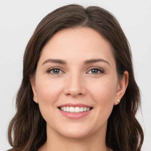 Joyful white young-adult female with long  brown hair and grey eyes