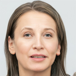 Joyful white adult female with long  brown hair and grey eyes