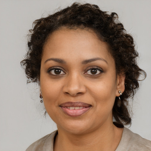 Joyful black young-adult female with medium  brown hair and brown eyes