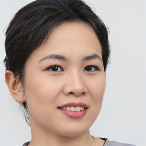 Joyful asian young-adult female with medium  brown hair and brown eyes