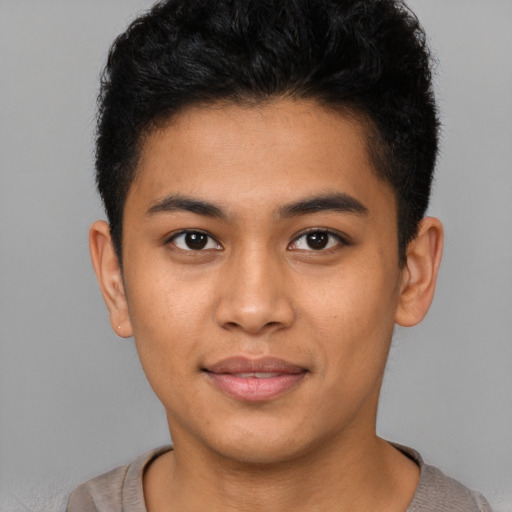 Joyful latino young-adult male with short  brown hair and brown eyes