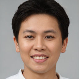 Joyful asian young-adult male with short  brown hair and brown eyes