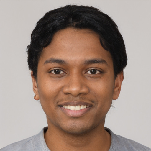 Joyful black young-adult male with short  black hair and brown eyes