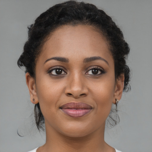 Joyful black young-adult female with medium  brown hair and brown eyes