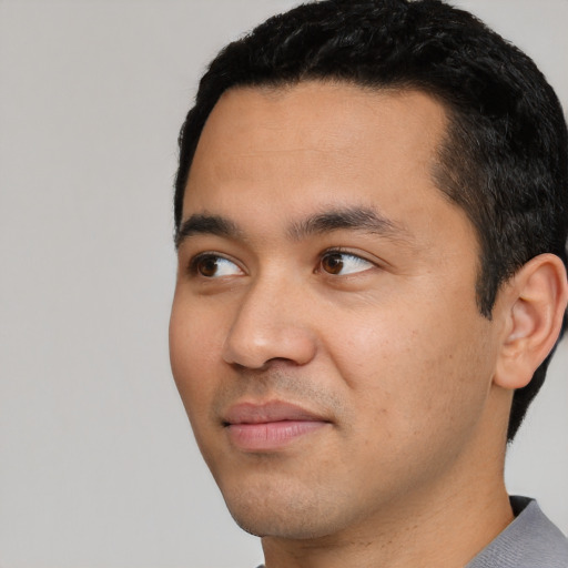Joyful white young-adult male with short  black hair and brown eyes