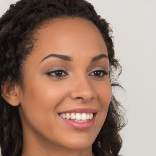 Joyful latino young-adult female with long  brown hair and brown eyes