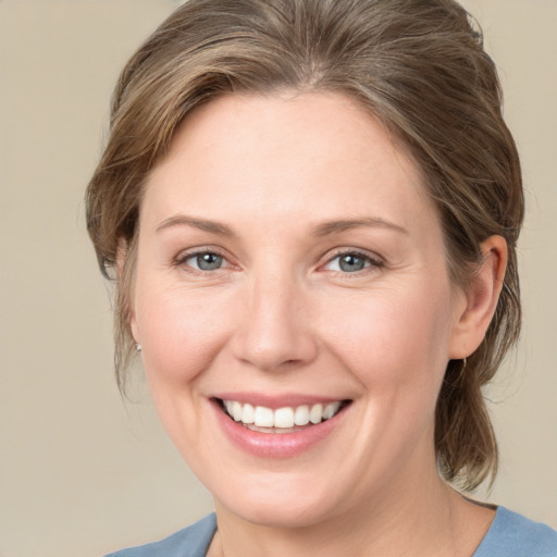 Joyful white young-adult female with medium  brown hair and grey eyes