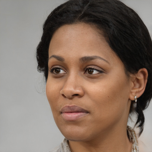Joyful black young-adult female with medium  brown hair and brown eyes