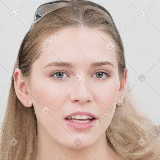 Joyful white young-adult female with long  brown hair and blue eyes