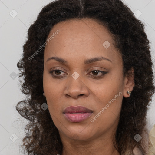 Joyful black adult female with long  brown hair and brown eyes