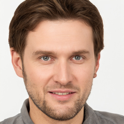 Joyful white young-adult male with short  brown hair and grey eyes