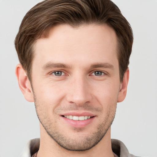 Joyful white young-adult male with short  brown hair and grey eyes