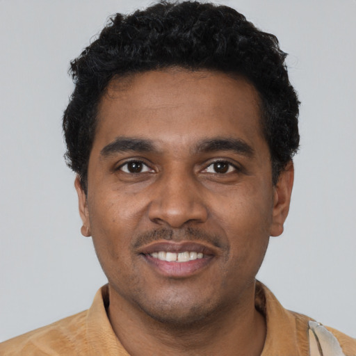 Joyful black young-adult male with short  black hair and brown eyes