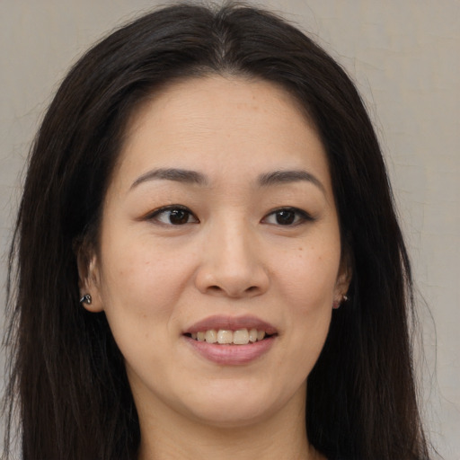 Joyful asian young-adult female with long  brown hair and brown eyes