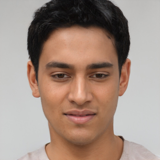 Joyful latino young-adult male with short  black hair and brown eyes