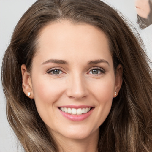 Joyful white young-adult female with long  brown hair and brown eyes