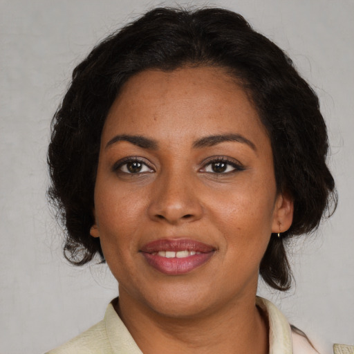Joyful black adult female with medium  brown hair and brown eyes