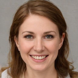 Joyful white young-adult female with medium  brown hair and grey eyes