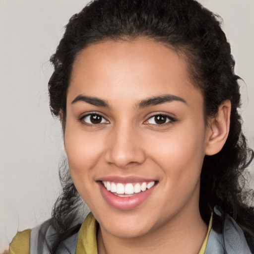 Joyful latino young-adult female with long  brown hair and brown eyes