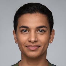 Joyful latino young-adult male with short  black hair and brown eyes