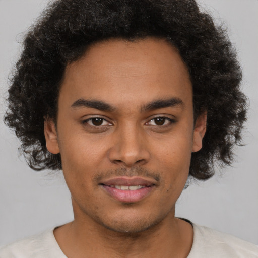 Joyful black young-adult male with short  brown hair and brown eyes