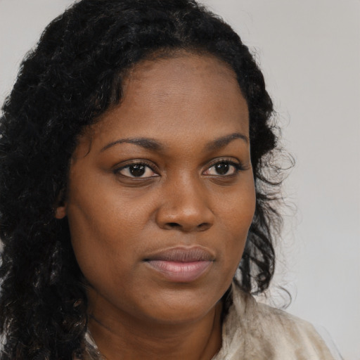 Joyful black young-adult female with long  brown hair and brown eyes