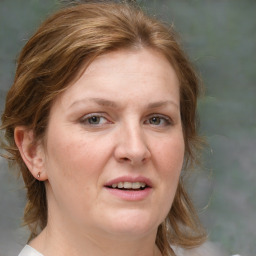 Joyful white adult female with medium  brown hair and blue eyes