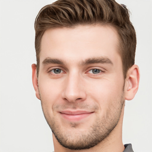 Joyful white young-adult male with short  brown hair and grey eyes