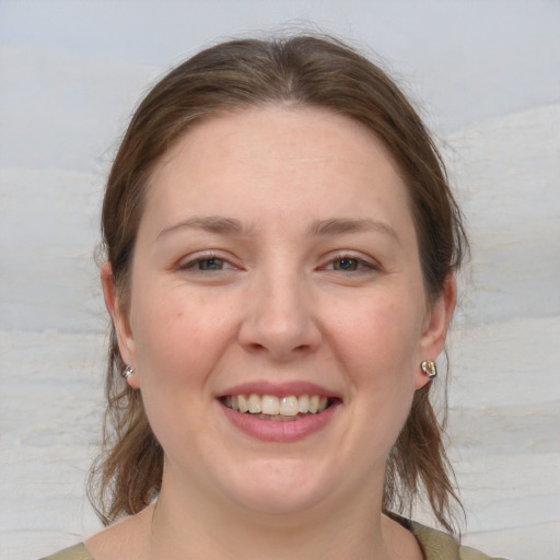 Joyful white young-adult female with medium  brown hair and blue eyes