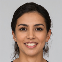 Joyful latino young-adult female with medium  brown hair and brown eyes