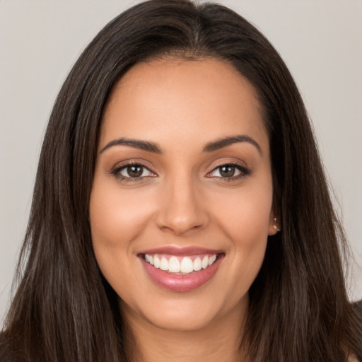 Joyful white young-adult female with long  brown hair and brown eyes