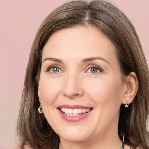 Joyful white adult female with medium  brown hair and grey eyes