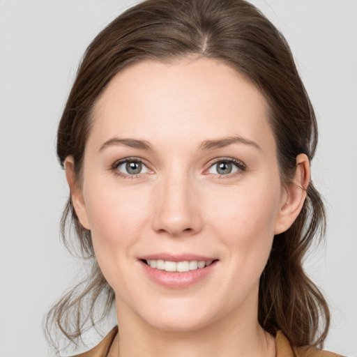 Joyful white young-adult female with medium  brown hair and grey eyes