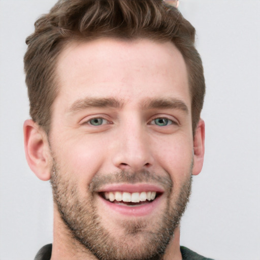 Joyful white young-adult male with short  brown hair and blue eyes