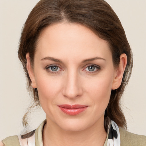 Joyful white young-adult female with medium  brown hair and grey eyes