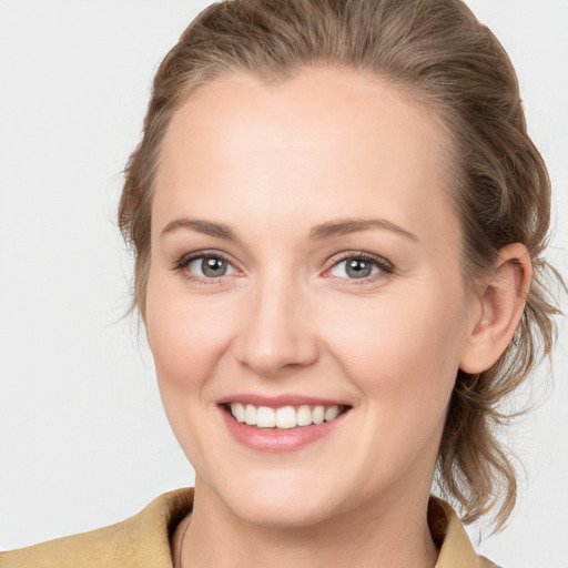 Joyful white young-adult female with medium  brown hair and grey eyes