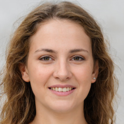 Joyful white young-adult female with long  brown hair and green eyes