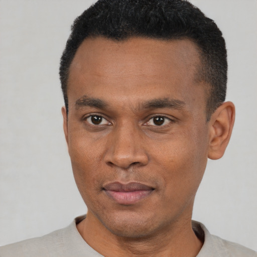 Joyful black young-adult male with short  black hair and brown eyes