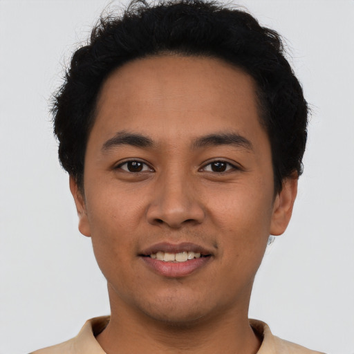 Joyful latino young-adult male with short  brown hair and brown eyes