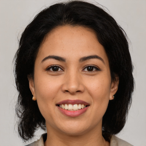 Joyful latino young-adult female with medium  brown hair and brown eyes