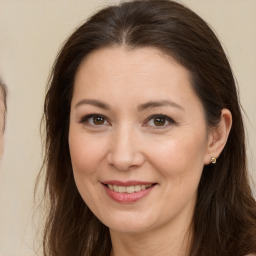 Joyful white adult female with long  brown hair and brown eyes