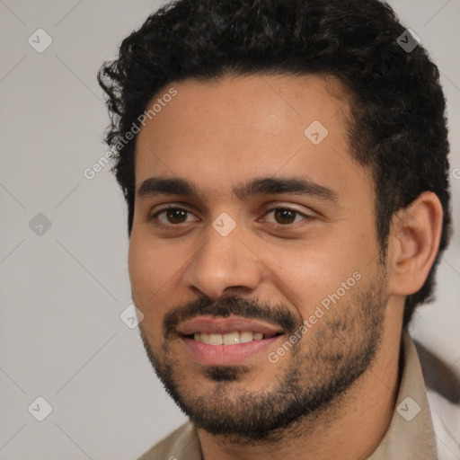 Joyful latino young-adult male with short  black hair and brown eyes